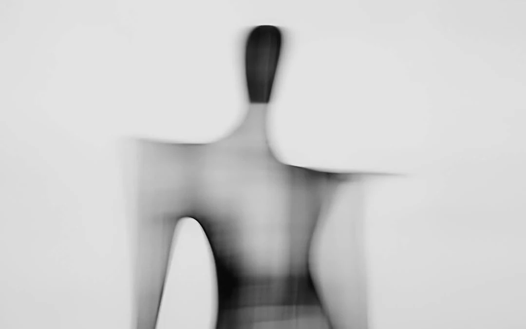 A blurred black and white figure caught in motion.